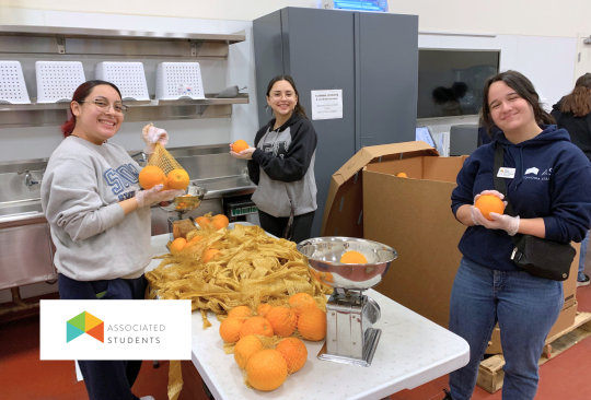 Students weighing produce in a commercial kitchen.