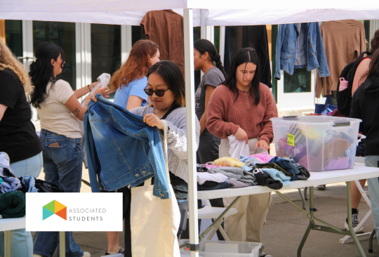 Students picking out clothes from an AS pop up tent.