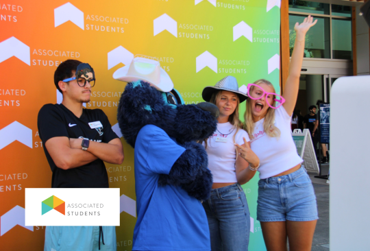 Students posing with lobo at a photo backdrop.