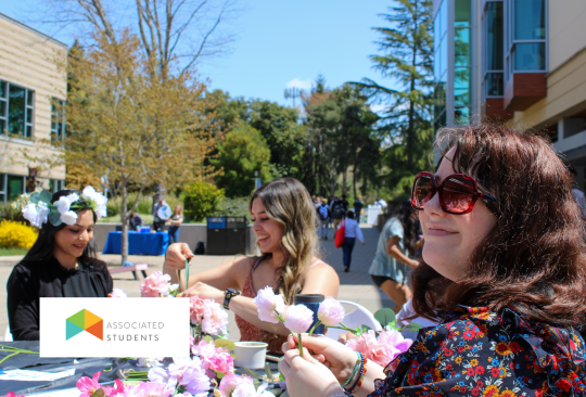 A group of people crafting at tables in Seawolf Plaza.